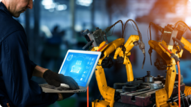 Homem acompanhando a utilização de uma máquina robotizada no computador